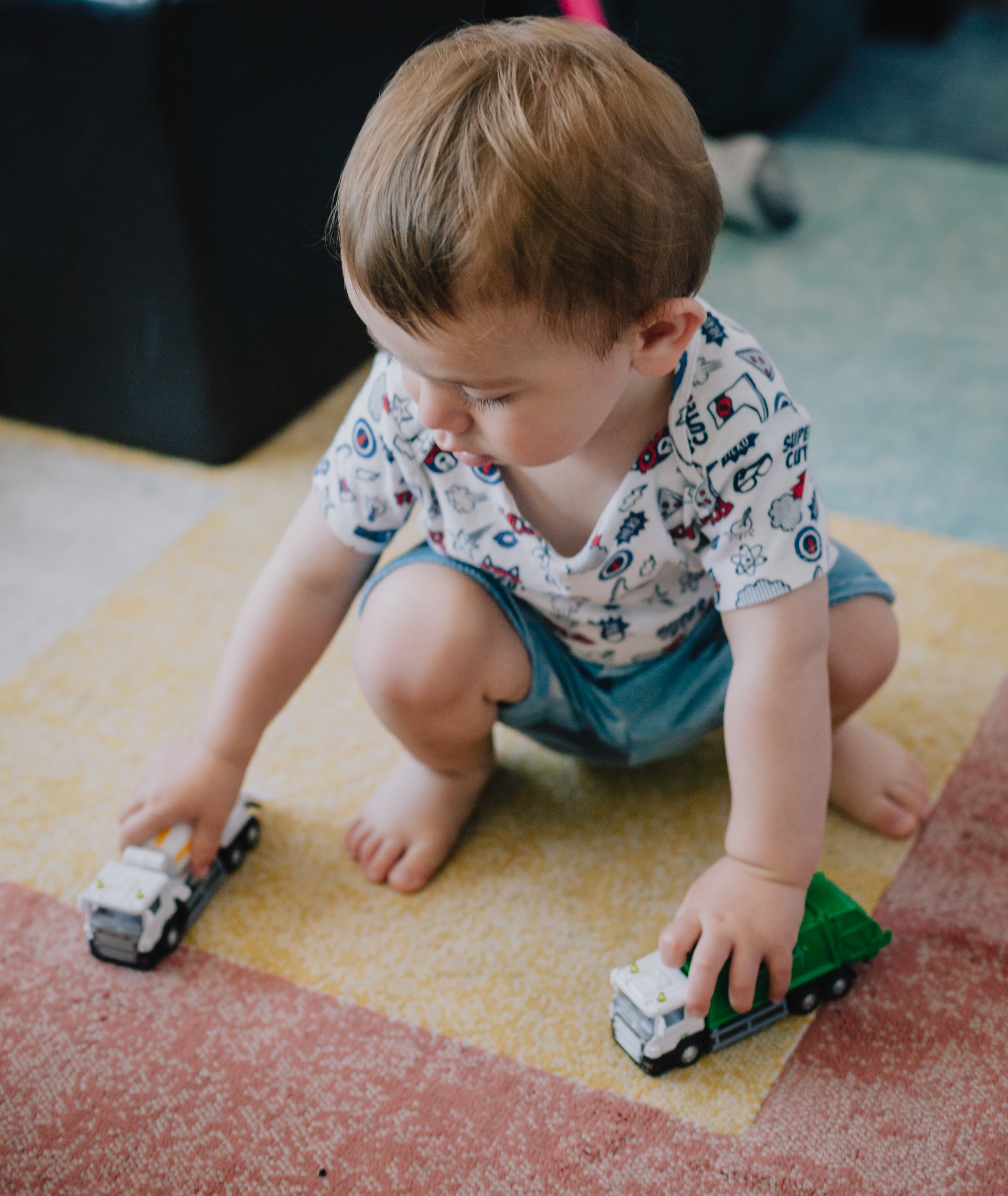 small-child-squats-and-plays-with-toy-trucks.jpg